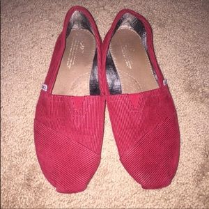 Red corduroy TOMS slip ons with purple sole